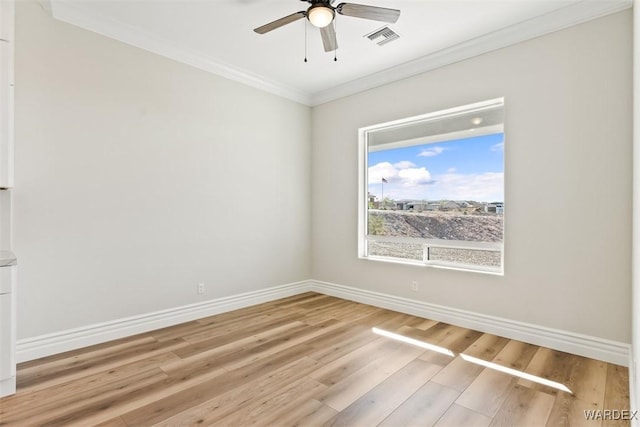 spare room featuring baseboards, visible vents, and crown molding