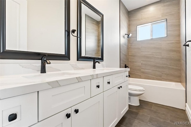 full bath with double vanity, bathing tub / shower combination, a sink, and toilet