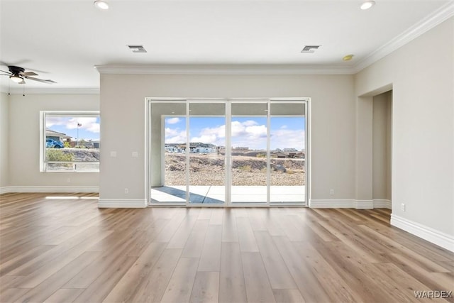 unfurnished living room featuring plenty of natural light, ornamental molding, and wood finished floors