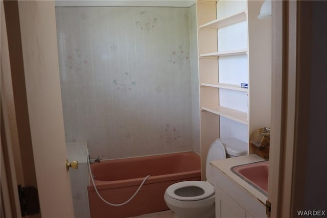 bathroom with a washtub, vanity, and toilet