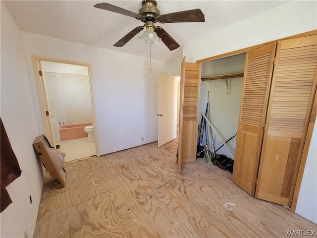 unfurnished bedroom with a textured ceiling, a closet, connected bathroom, and a ceiling fan