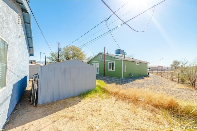 exterior space with an outbuilding, fence, and a shed