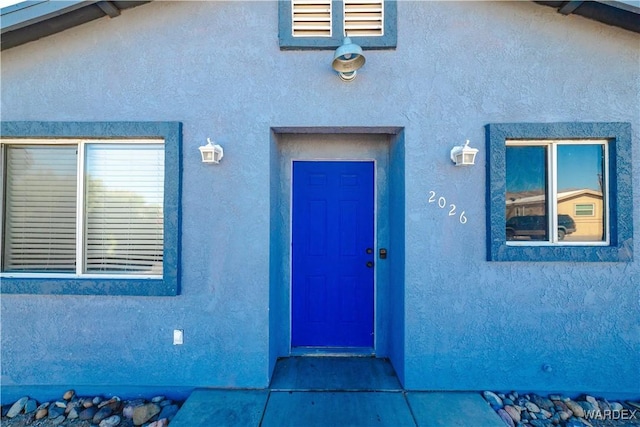 view of exterior entry with stucco siding