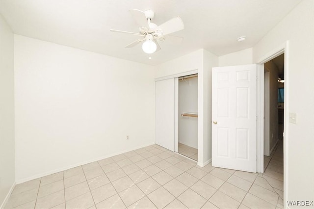 unfurnished bedroom featuring light tile patterned floors, ceiling fan, baseboards, and a closet