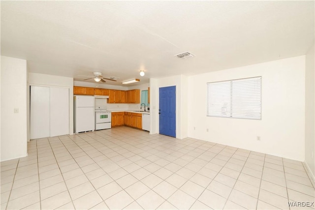 kitchen featuring white appliances, visible vents, brown cabinetry, ceiling fan, and light countertops