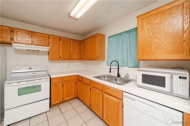 kitchen with white appliances, a sink, under cabinet range hood, and light tile patterned floors