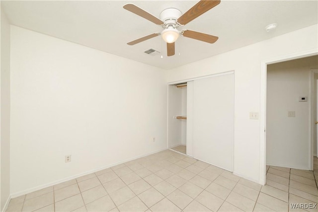 unfurnished bedroom with ceiling fan, light tile patterned flooring, visible vents, baseboards, and a closet