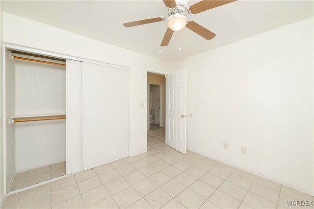 unfurnished bedroom with ceiling fan, light tile patterned floors, a closet, and baseboards