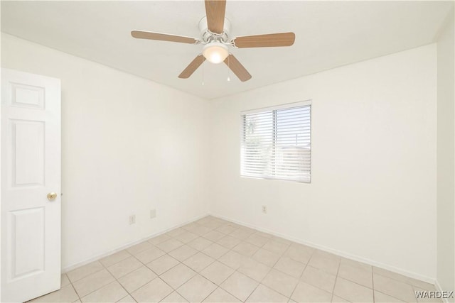 spare room featuring a ceiling fan and baseboards