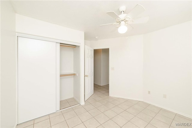 unfurnished bedroom with light tile patterned floors, baseboards, a ceiling fan, and a closet