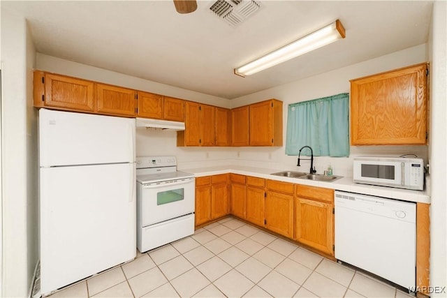 kitchen with white appliances, visible vents, light countertops, under cabinet range hood, and a sink