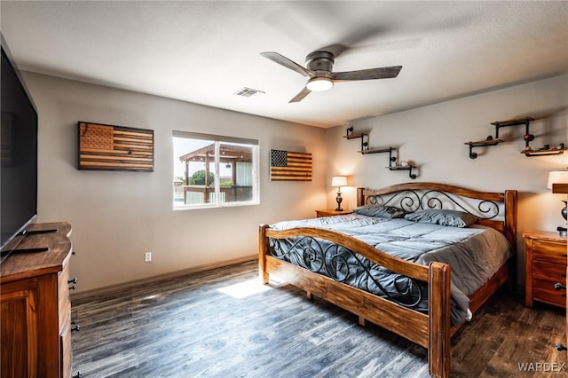 bedroom with dark wood-style flooring, visible vents, ceiling fan, and baseboards