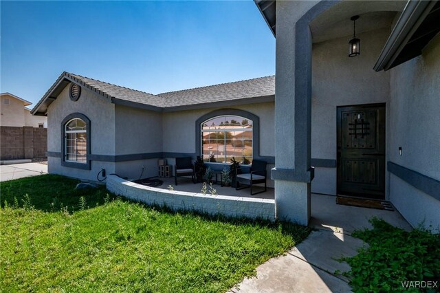 exterior space with stucco siding, fence, a patio, and a yard