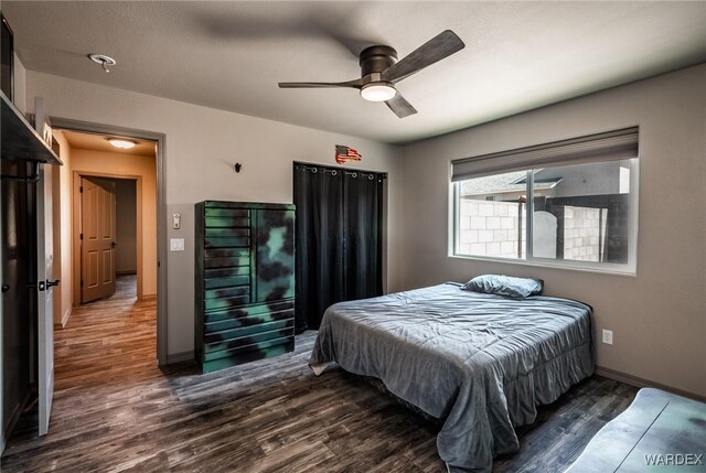 bedroom with ceiling fan, baseboards, and wood finished floors