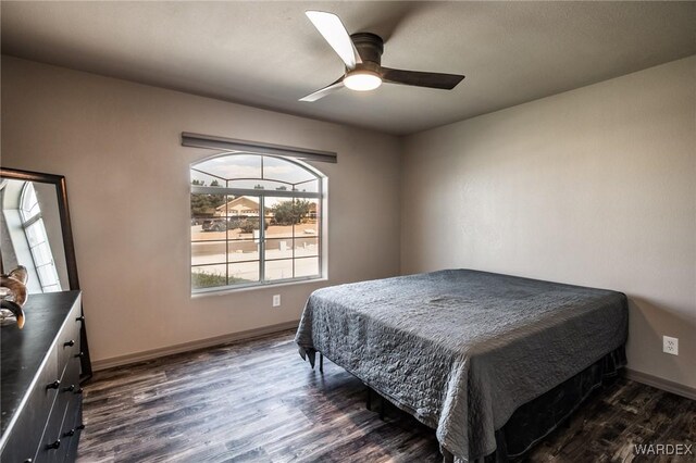 bedroom featuring dark wood-type flooring, baseboards, and a ceiling fan