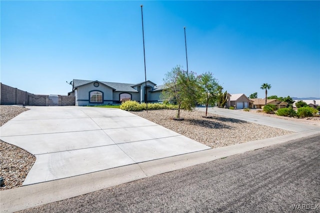 single story home with fence and concrete driveway