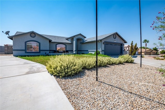 single story home featuring a garage, driveway, and stucco siding