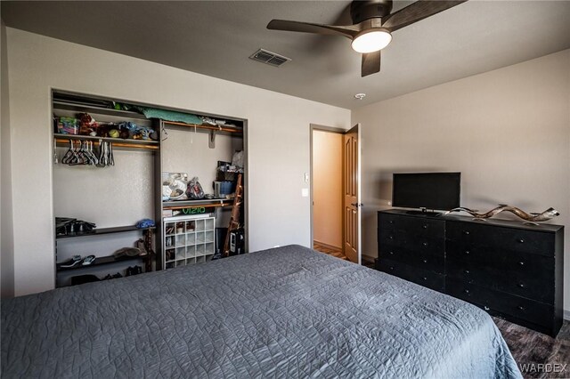 bedroom with ceiling fan, a closet, wood finished floors, and visible vents