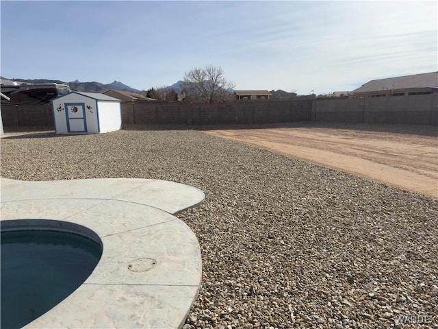 view of yard featuring an outbuilding, a patio area, a fenced backyard, and a shed