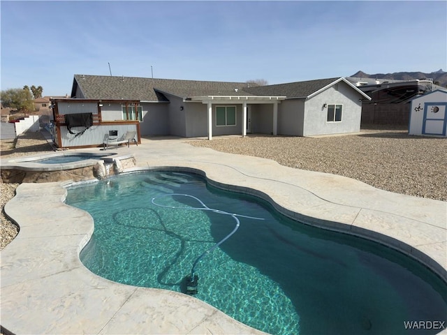 view of pool with a patio area and a pool with connected hot tub