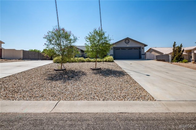 ranch-style home with concrete driveway, fence, an attached garage, and stucco siding