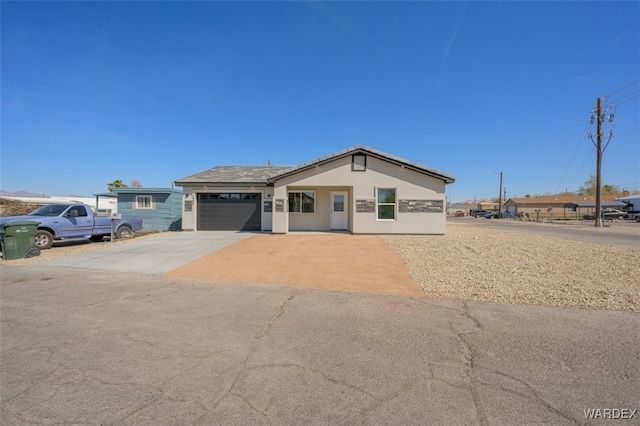 ranch-style house featuring an attached garage, driveway, and stucco siding