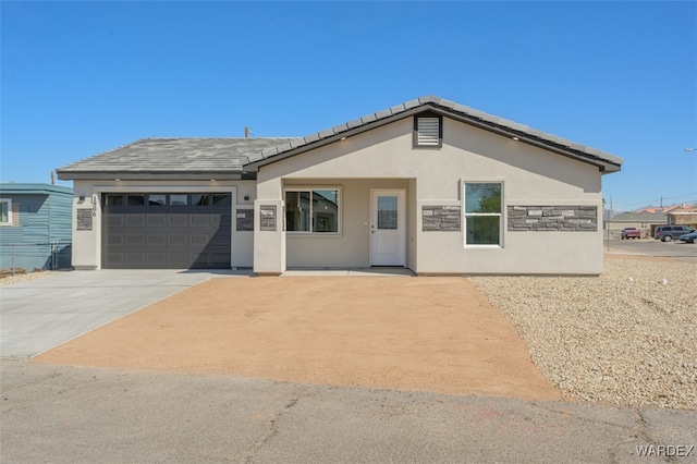 single story home featuring a garage, concrete driveway, and stucco siding