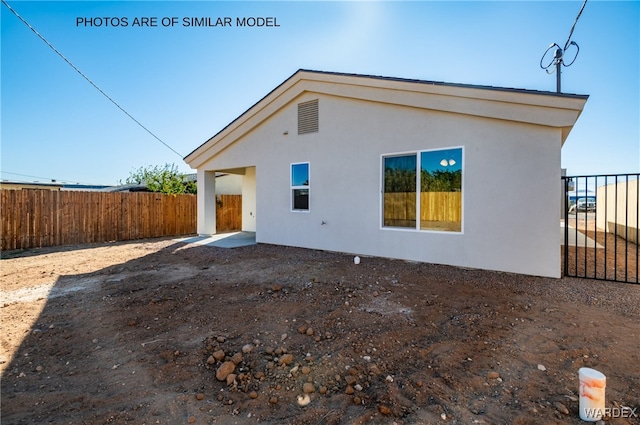 back of property featuring fence and stucco siding