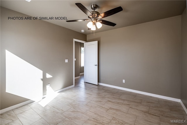 empty room featuring ceiling fan and baseboards