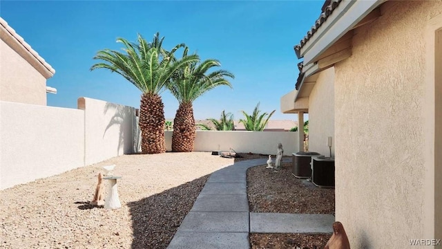 view of yard featuring a fenced backyard and central AC