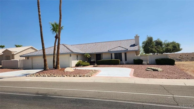 ranch-style home with driveway, a tiled roof, an attached garage, fence, and stucco siding