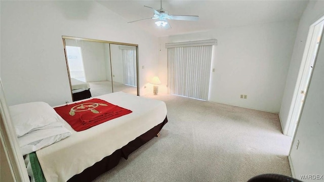 bedroom with lofted ceiling, a closet, light carpet, and ceiling fan