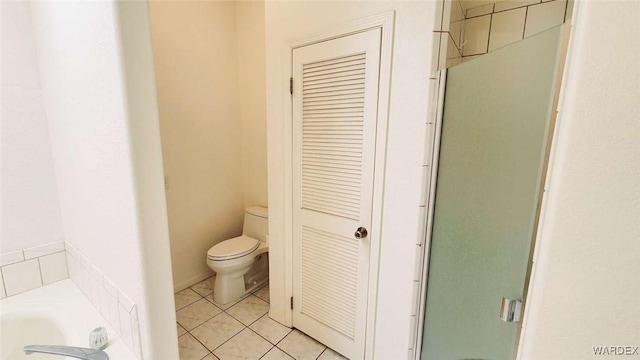 bathroom with toilet, a stall shower, a closet, and tile patterned floors