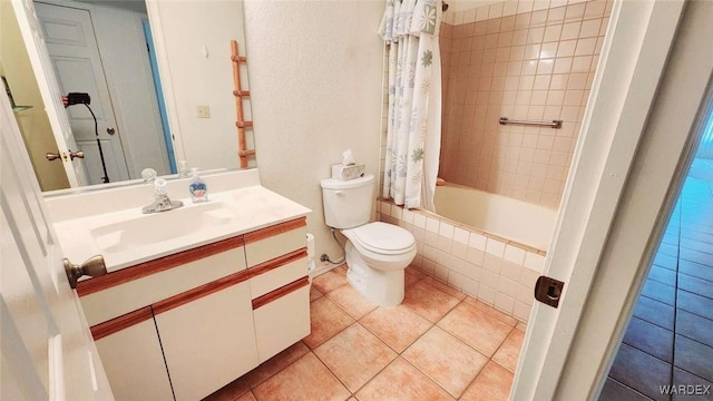 bathroom featuring toilet, tiled shower / bath combo, tile patterned flooring, and vanity