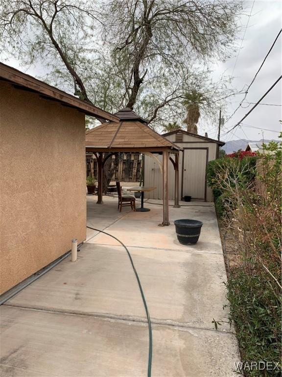 view of patio featuring an outbuilding, a gazebo, and a shed