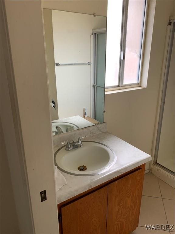 bathroom featuring tile patterned floors, a shower stall, and vanity