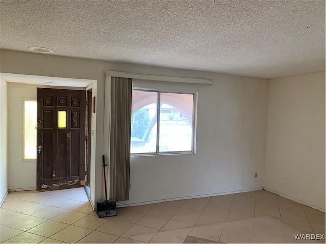 foyer entrance with a textured ceiling