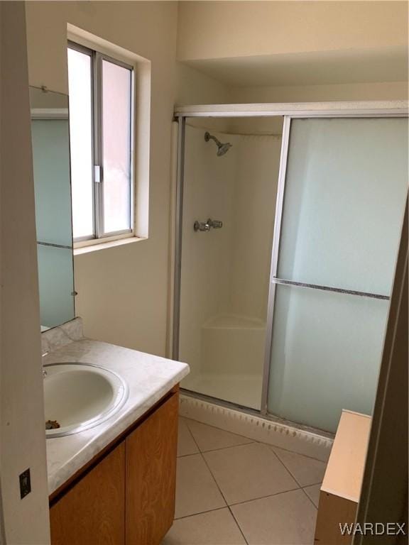 full bathroom with a stall shower, tile patterned flooring, and vanity