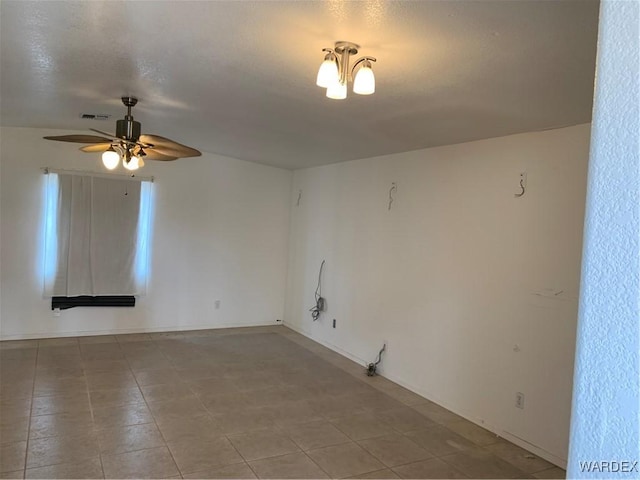 spare room featuring ceiling fan and visible vents