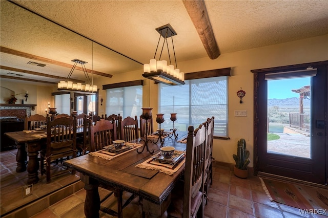 dining space featuring beam ceiling, a notable chandelier, visible vents, a textured ceiling, and baseboards