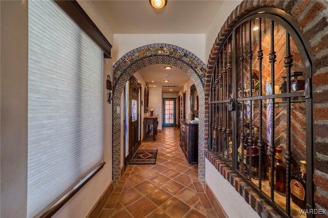 corridor with arched walkways and tile patterned floors