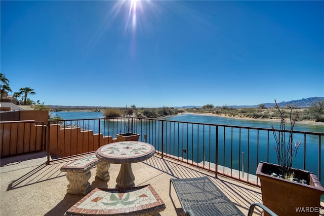 view of patio with a balcony and a water view