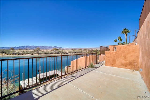 view of patio featuring a water and mountain view