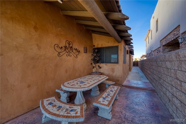 patio terrace at dusk featuring fence