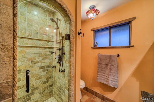 bathroom with toilet, a shower stall, and tile patterned floors