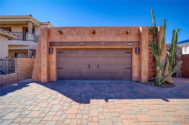 garage with fence and decorative driveway