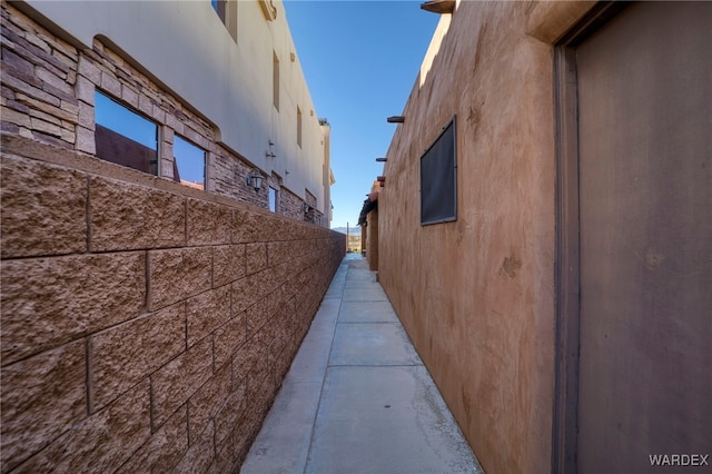 view of side of property with fence and stucco siding