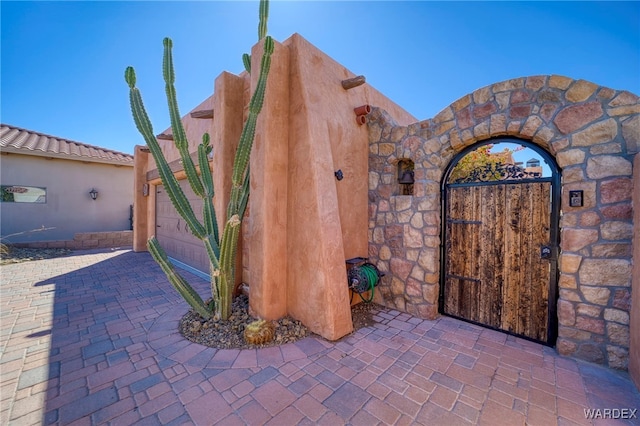 exterior space with an attached garage and decorative driveway