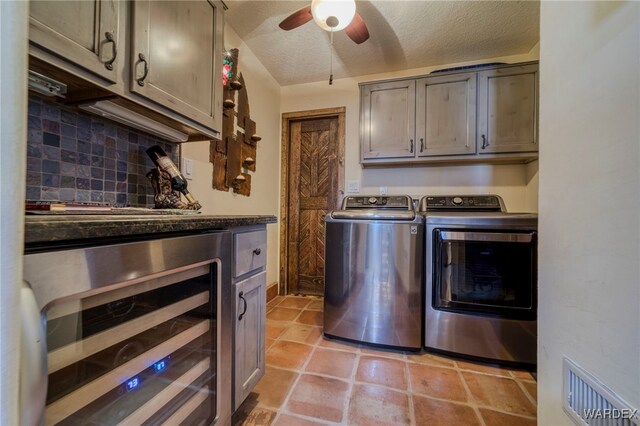 clothes washing area with beverage cooler, visible vents, a ceiling fan, a textured ceiling, and washing machine and dryer