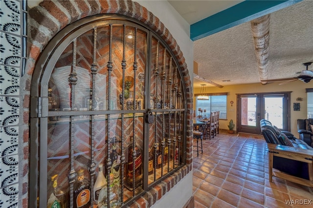 interior space featuring tile patterned flooring, a textured ceiling, and french doors